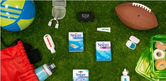 A lawn with a football, volleyball, mouthguard, and assorted Nexcare™ Bandages and tapes.
