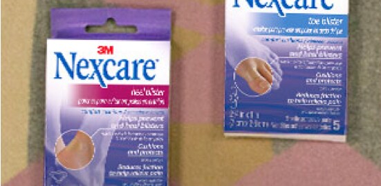 Une boîte de Pansements confort pour ampoule aux chevilles et aux orteils Nexcare(MC)sur un couvre-lit.
