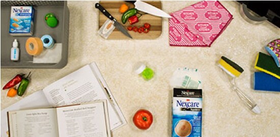 A kitchen counter with a knife and cutting board, and assorted Nexcare™ Bandages.
